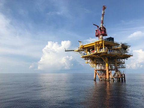 Small offshore platform on a calm sea under a partly cloudy sky