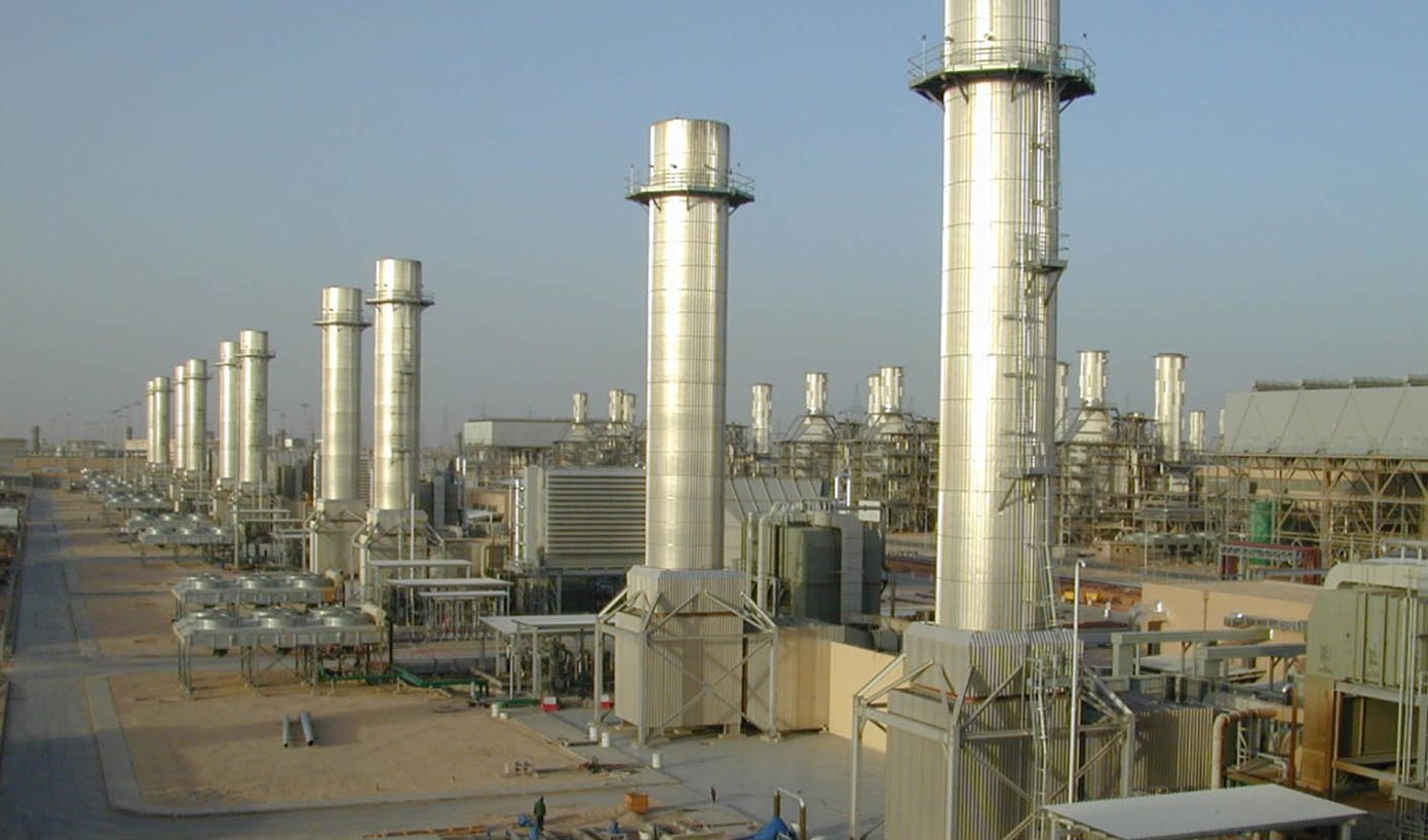 Combined-cycle gas turbine plant with tall exhaust stacks in daylight