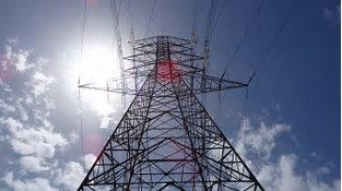 High-voltage electricity transmission tower against the sun